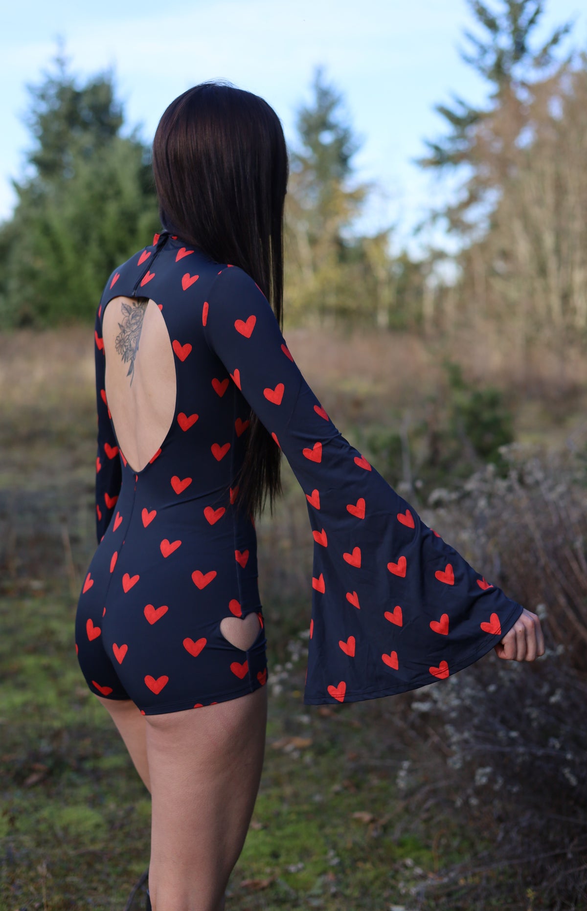Side view of the Heart Cutout Bodysuit showing the fitted shorts and flowing bell sleeve